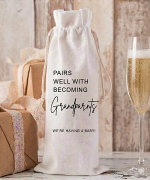 A Personalised New Grandparents Wine Bottle Bag made of cream linen with black text saying Pairs Well With Becoming Grandparents We are Having A Baby.