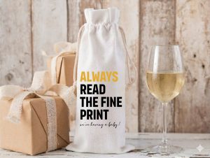 A cream linen wine bottle bag with black text that reads Pairs Well With Becoming Grandparents We Are Having A Baby pregnancy announcement