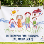 Personalised white cotton tea towel featuring a real childs colourful crayon drawing of a family and house.
